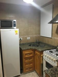 uma cozinha com um frigorífico branco e um lavatório em Apartamento Los Abuelos em Colón