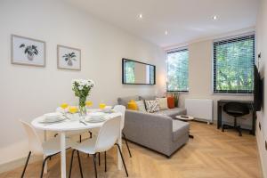 a living room with a table and a couch at Luxury Flat Near Hove Station parking sleeps 4 in Moffat