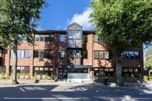 a brick building with a tree in front of it at Luxury Flat Near Hove Station parking sleeps 4 in Moffat