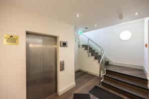 a hallway with stairs and a metal elevator at Luxury Flat Near Hove Station parking sleeps 4 in Moffat