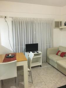 uma sala de estar com um sofá e uma mesa com um computador em Apartamento Los Abuelos em Colón