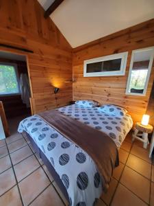 a bedroom with a bed in a room with wooden walls at Les Cabanes de Rouffignac in Rouffignac Saint-Cernin