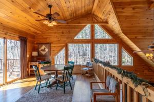 a dining room with a table and chairs in a cabin at Our Neck of the Woods at Hidden Lake in Nebo