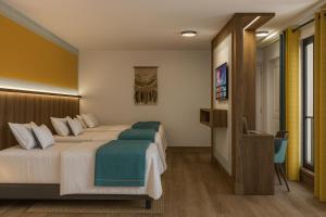 Una habitación de hotel con dos camas y un televisor. en Hanaqua Hotel, en Cusco