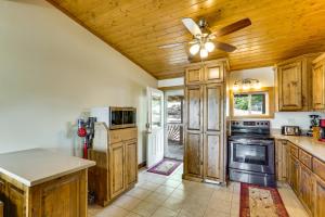 een keuken met houten kasten en een plafondventilator bij Ozarks Waterfront Home with Dock and Marina Access in Warsaw +16 foto's