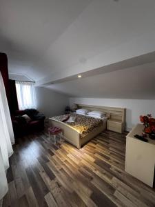 a bedroom with a bed and a chair in a room at Mansarda lu' Ion in Tîrgu Neamţ