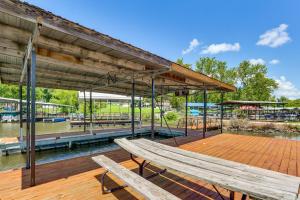 een houten dek met twee banken op een steiger bij Ozarks Waterfront Home with Dock and Marina Access in Warsaw