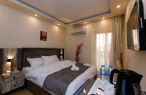 um quarto de hotel com uma cama e uma secretária com uma secretária em AKEN Pyramids View em Cairo