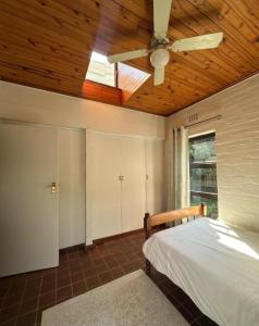 a bedroom with a ceiling fan and a bed at Stone Trading Pty Ltd in Durban