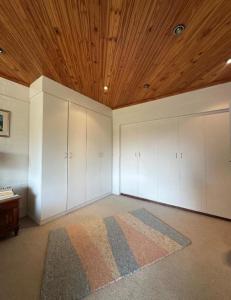 an empty room with white cabinets and a wooden ceiling at Stone Trading Pty Ltd in Durban