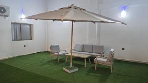 a table and chairs and an umbrella in a room at Hotel Principale Smara CPS in Smara