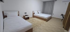 a hotel room with two beds and a desk at Hotel Principale Smara CPS in Smara