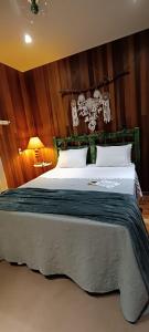 a bedroom with a large bed with wooden walls at Morada das Mandalas in Pomerode