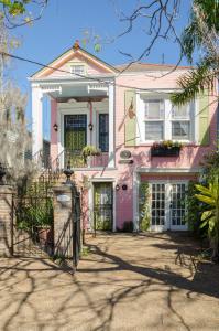 a pink house with a gate in front of it at Madame Isabelle's House in New Orleans