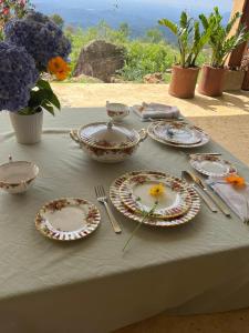 a table with plates and utensils on top of it at Blackwoods Farmhouse in Beragala