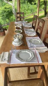 a wooden table with plates and dishes on it at Blackwoods Farmhouse in Beragala