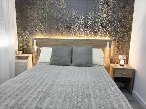 a bedroom with a large bed and a wall at Vivienda en centro de Yecla in Yecla