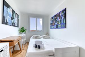 a white room with a bed and a desk at Appartement Le perchoir - Welkeys in La Guillotière +7 photos