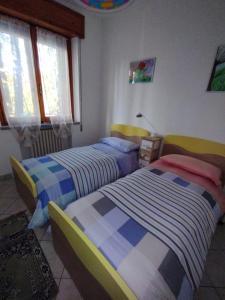 une chambre avec deux lits et une fenêtre dans l'établissement Casa Giulia, à Mercatino Conca