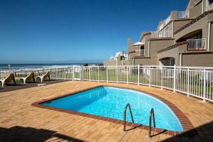 una piscina frente a un edificio en Jeffreys Bay Beach Accommodation Waters Edge, en Jeffreys Bay