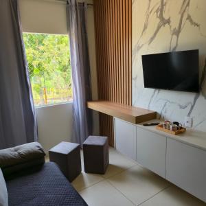 a room with a tv and a bed and a window at Ap Lagoa da Prata com Ar condicionado in Lagoa da Prata