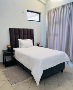 Un pat sau paturi într-o cameră la Botumo Apartment-2