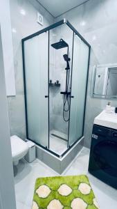 a bathroom with a shower and a green rug at Новая Евродвушка&Комфорт КЖБИ in Kostanay +23 photos
