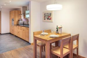 a kitchen and dining room with a wooden table and chairs at City Peak 2 Studio - in the heart of Zermatt in Zermatt
