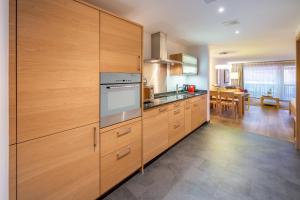 a kitchen with wooden cabinets and a stove at City Peak 2 Studio - in the heart of Zermatt in Zermatt
