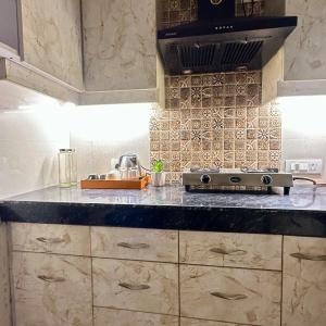 a kitchen with a stove and a counter top at Cozy & Comfy 1BHK in Sector 46 in Noida