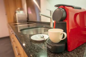 a coffee maker sitting on a counter with a coffee cup at City Peak 2 Studio - in the heart of Zermatt in Zermatt +7 photos