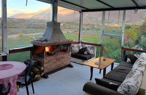 ein Wohnzimmer mit gemauertem Kamin mit Aussicht in der Unterkunft SuperPanorama GuestHouse in Kukës