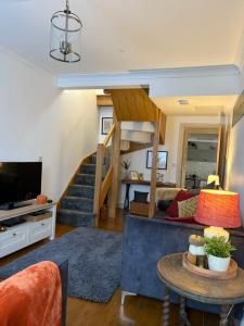 a living room with a couch and a staircase at Tŷ Twt in Pontardawe