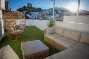 a living room with a couch and a chair on a balcony at Babel 11 Centro in Vélez de Benaudalla