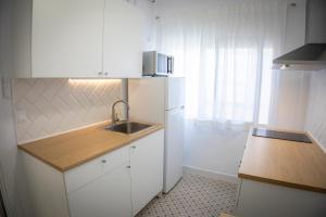 a kitchen with a sink and a white refrigerator at Babel 11 Centro in Vélez de Benaudalla