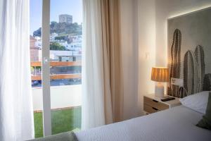 a bedroom with a bed and a large window at Babel 11 Centro in Vélez de Benaudalla