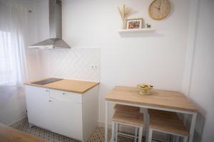 a small kitchen with a table and a clock on the wall at Babel 11 Centro in Vélez de Benaudalla +17 photos