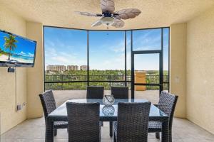 a dining room with a table and chairs and a ceiling fan at Fantastic Three Bedroom Condo With Balcony in Shell Point Village +16 photos