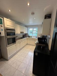 a kitchen with white cabinets and a large window at King Room in Windsor with Private Bathroom in Windsor +18 photos