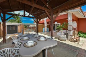 ノールトにあるBeach house with pool in noordのパティオ(テーブル、椅子付)