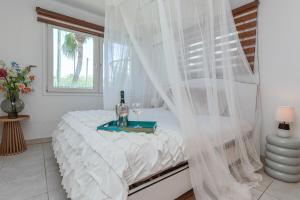 ノールトにあるBeach house with pool in noordの白いベッドルーム(テーブル付きのベッド付) +62枚の写真