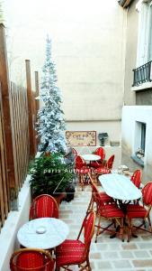 a patio with tables and chairs and a christmas tree at PARIS AUTHENTIC HOUSE open space studio Métro 14 Hôpital Bicêtre, RER B Gentilly in Gentilly
