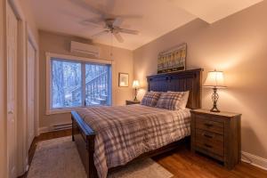 Un dormitorio con una cama con ventilador de techo y una ventana. en Blue Ridge Vista, en Banner Elk