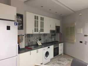 a kitchen with white cabinets and a washing machine at Losfresno beach in Puebla de Farnals