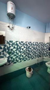 a bathroom with a toilet and a sink and a light at Ghumakkad Jodhpur in Jodhpur +15 photos