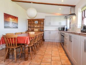 a kitchen with a table and chairs in a kitchen at Ty Gwartheg in Dinas
