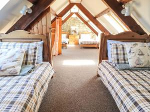two beds in a room with a attic at Ty Gwartheg in Dinas