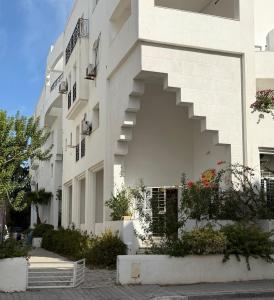 a white building with stairs on the side of it at Casaflor Tunis in Berges Du Lac