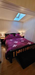 a bedroom with a large bed with a purple comforter at La Bergerie d'Espiaube in Saint-Lary-Soulan