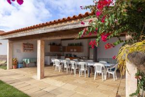 a patio with tables and chairs under a pergola at Montes de Praias GuestHouse in Aljezur